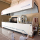 A satellite roughly the same size as Space Vehicle Four is loaded into a transport container.